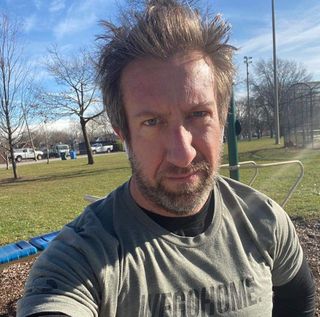 A selfie photo of Sergeant Nowacki in an olive green shirt at a park. 