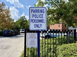 Two signs at the entrance to a parking lot. One reads in large font "PARKING POLICE PERSONNEL ONLY."

The other smaller sign, in a smaller font reads:
THIS PROPERTY IS OWNED AND CONTROLLED BY THE CITY OF CHICAGO.

IT MAY NOT BE USED FOR CIVIL IMMIGRATION ENFORCEMENT, AS A STAGING AREA, PROCESSING LOCATION, OR OPERATIONS BASE.
