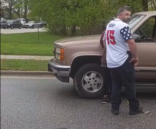 Man in white jersey with american flag sleeve pattern and TRUMP 45 on back in red numbers