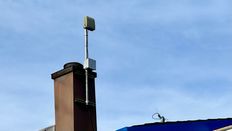 A ShotSpotter sensor attacked to a chimney.