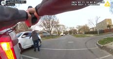 Frame from CPD body worn camera showing an officer pointing a gun at Dexter Reed's car with one other officer in view.